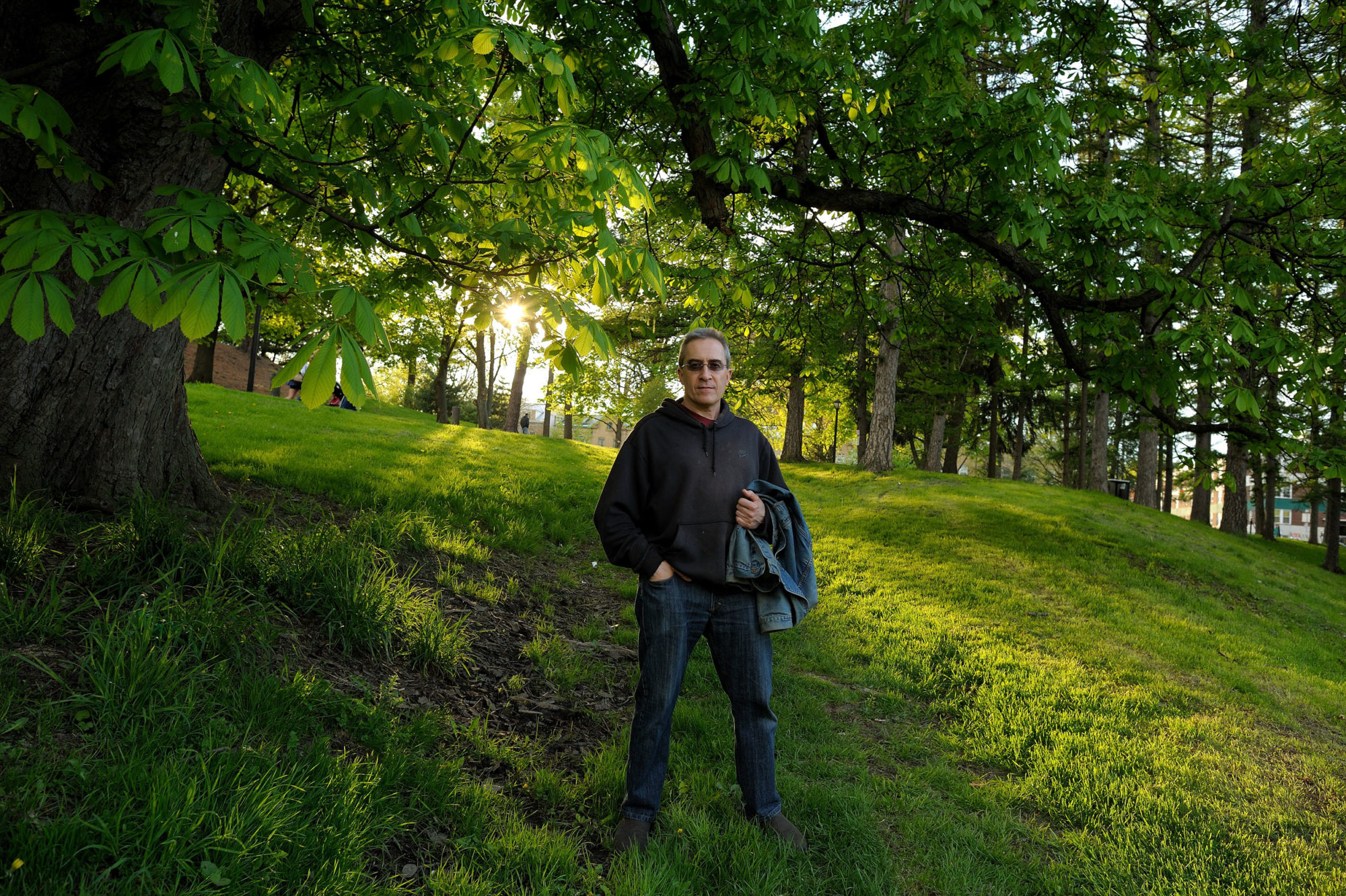 Man standing under trees after a rainfall.