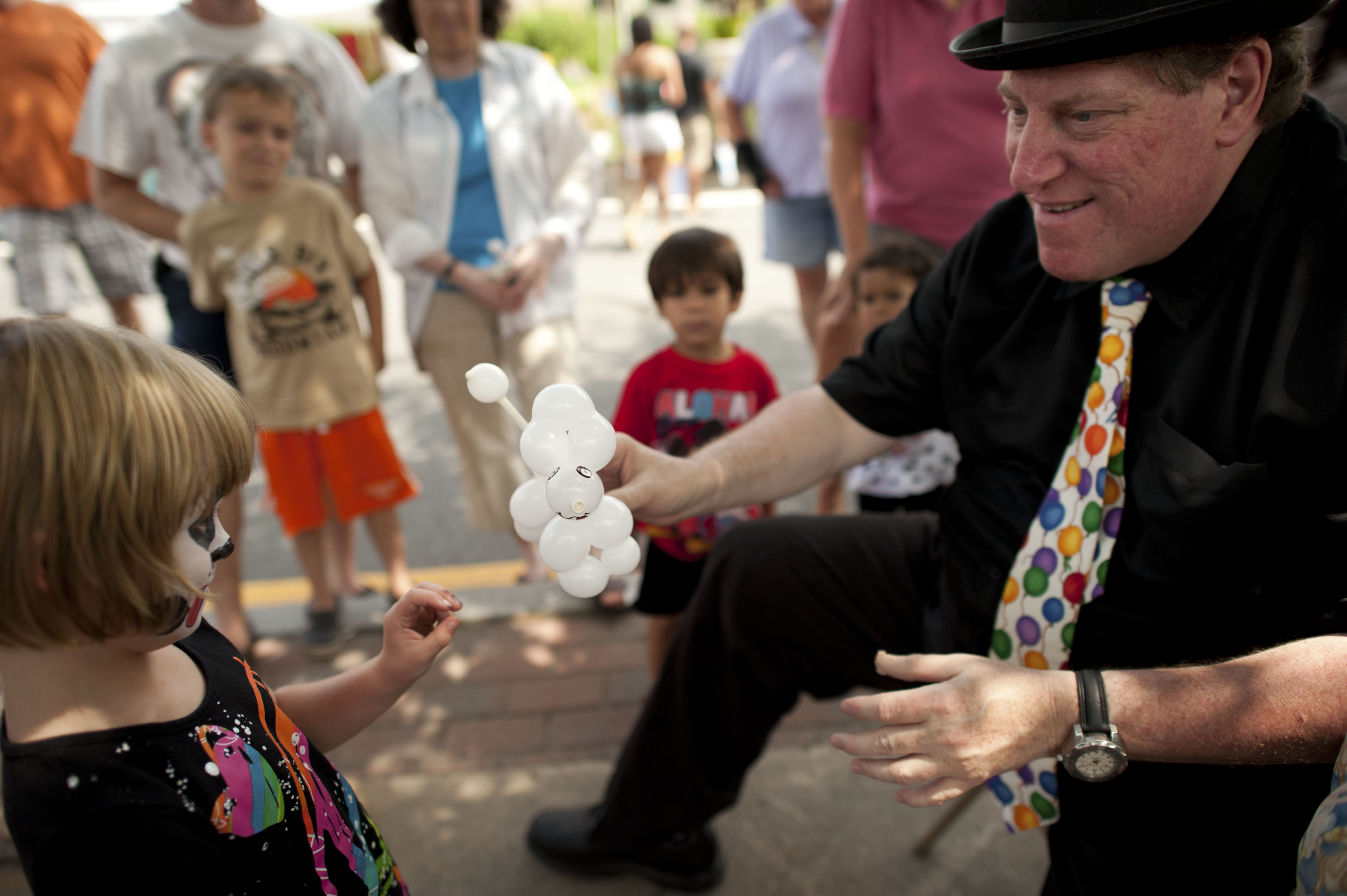 Bowie the Magic Clown whipped up a balloon poodle for a tentative youngster. 2011. Taken over my shoulder as I passed by.